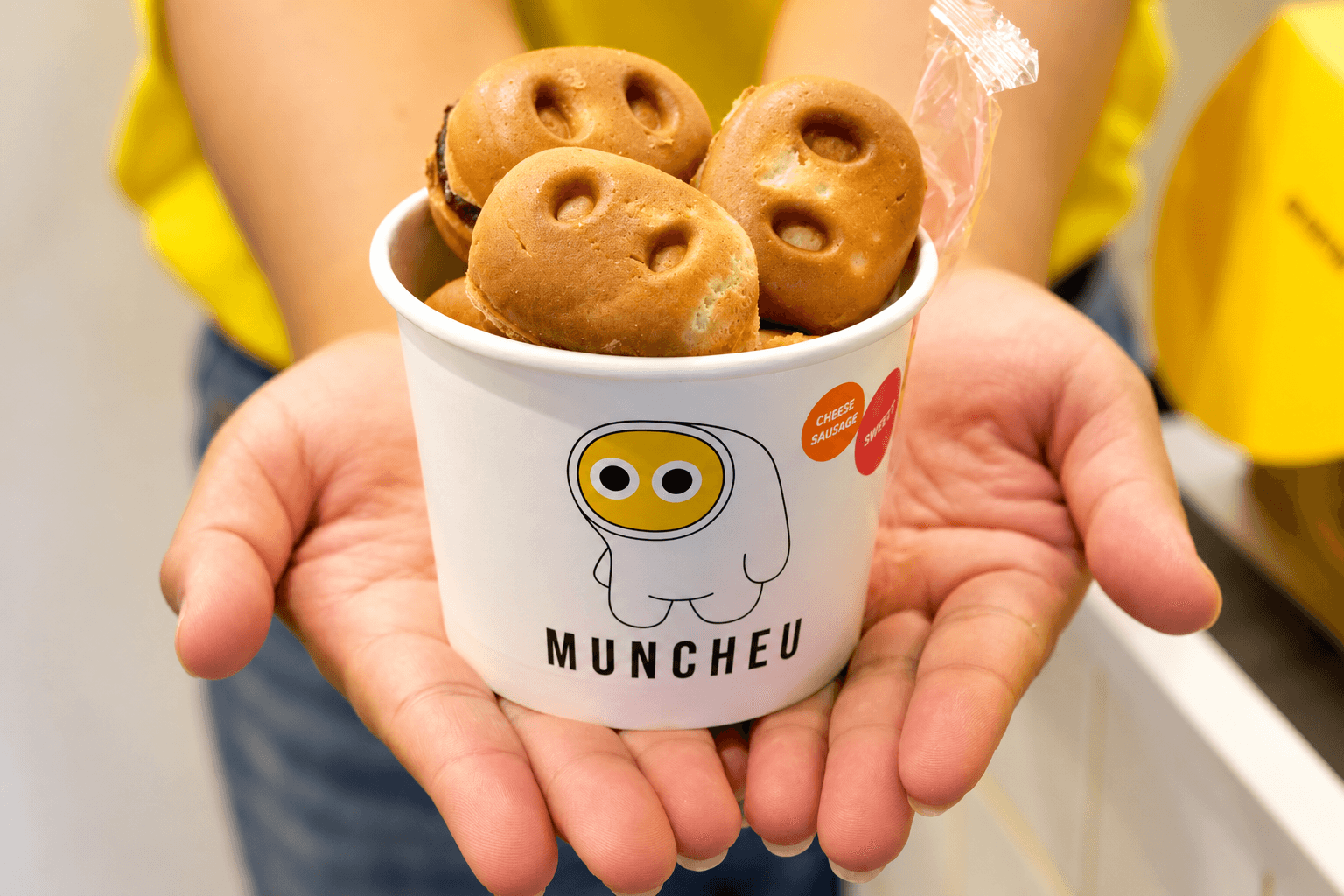 Hands holding a cup of MUNCHEU manju