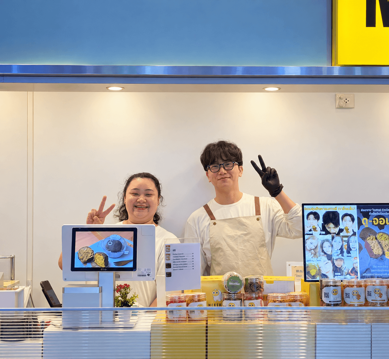 Two MUNCHEU teammates smiling behind the counter
